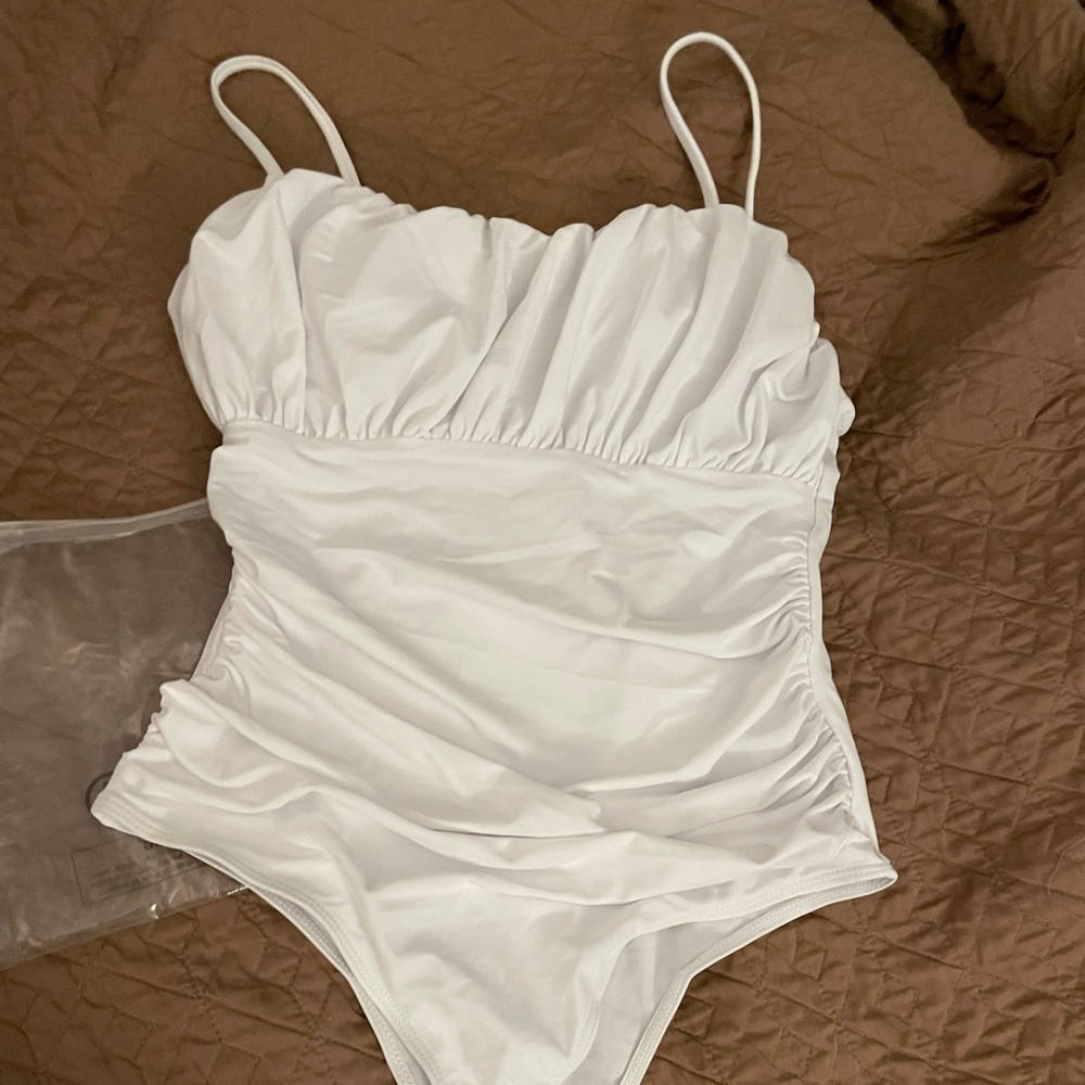 New with original bag and sanitary strip. White one piece swimsuit.